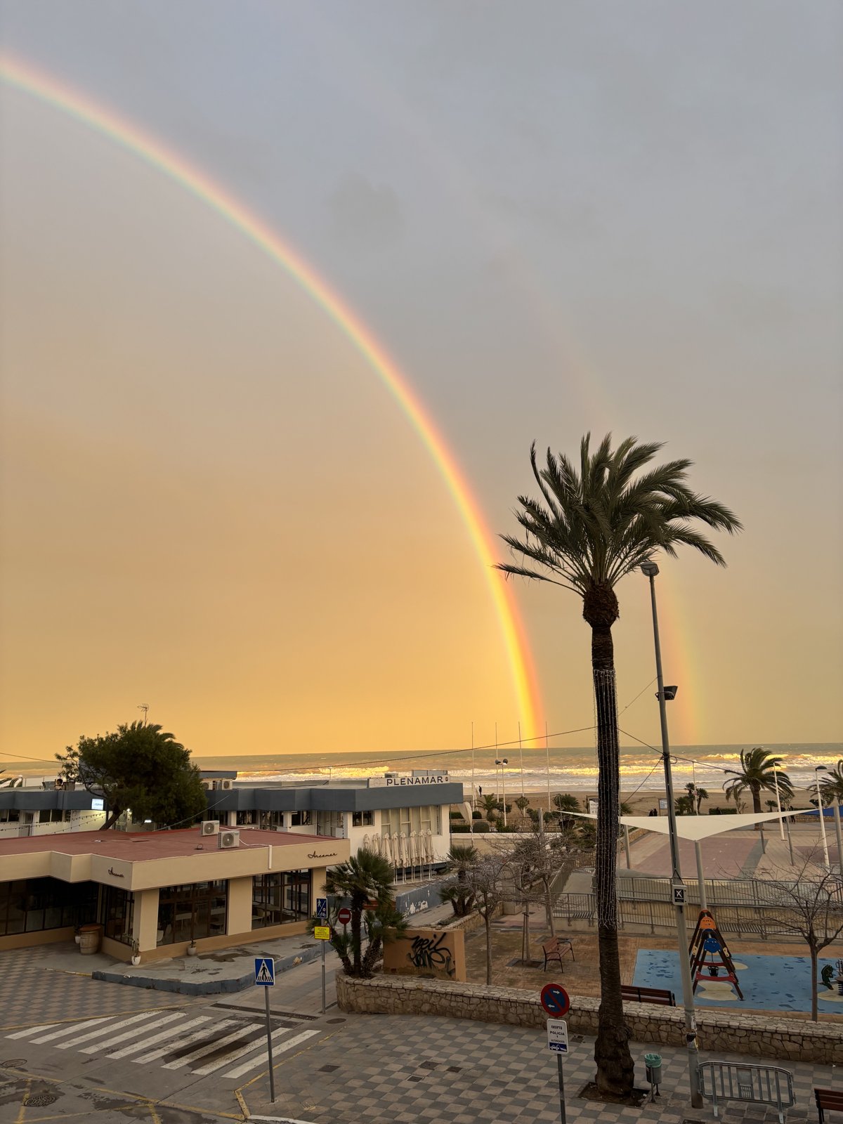 Doble arcoíris sobre el paseo marítimo, al atardecer